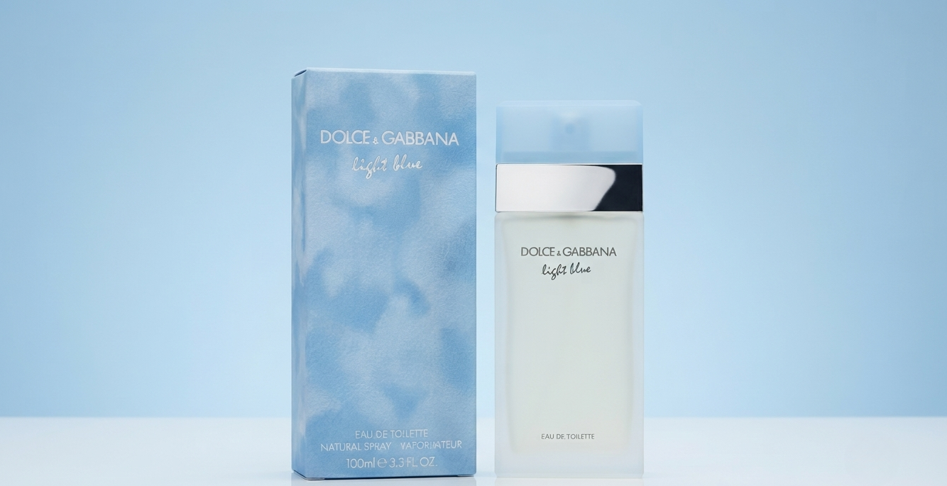 Dolce & Gabbana Light Blue cologne bottle and its matching blue cloud-patterned box, displayed on a clean white surface against a soft light blue background.